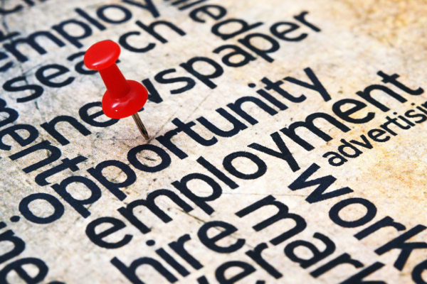 Red pushpin stuck in the word 'opportunity'