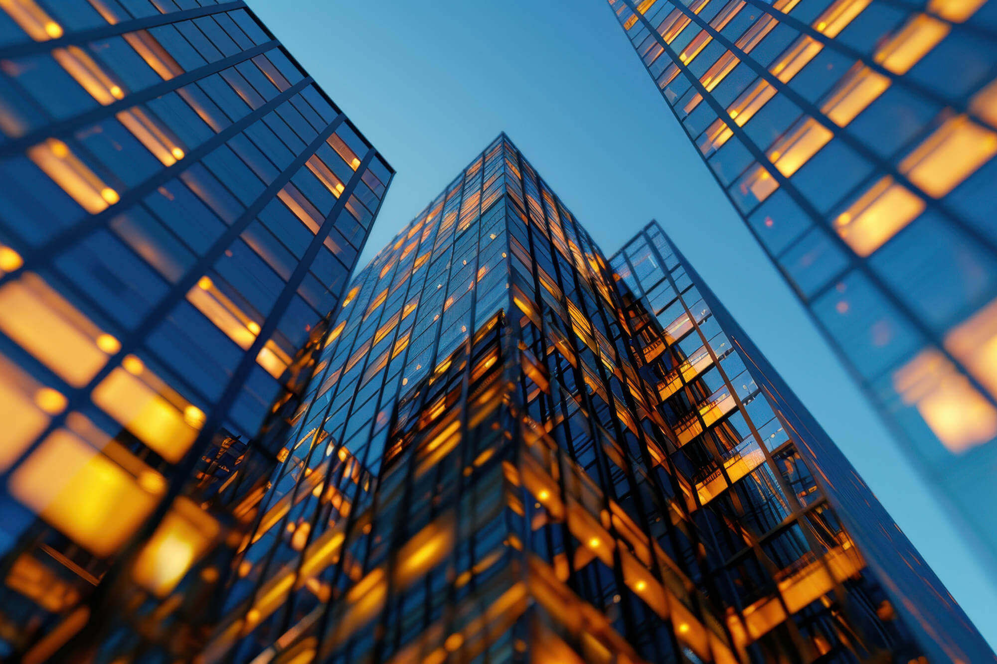 Modern skyskrapers in the evening sky, with orange lights in some windows